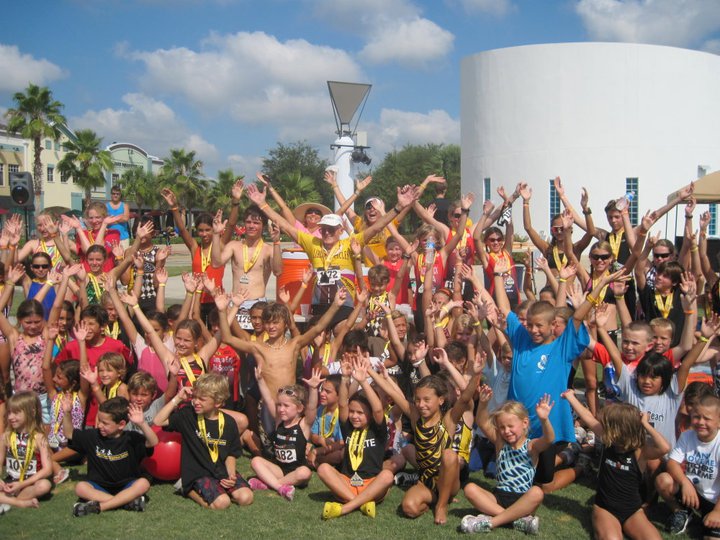Charlie and Kids with arms raised in celebration after YTS for Livestrong Triathlon Series races